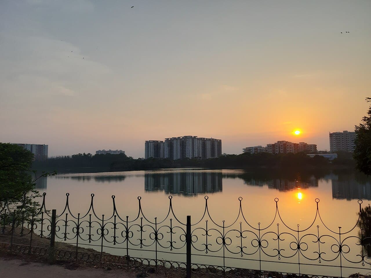 Sunset over Kaikondrahalli Lake with apartment towers across the water