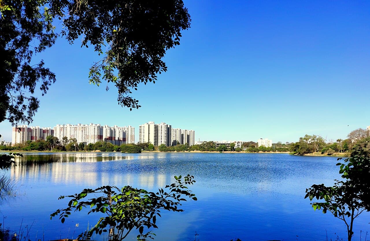 Kasavanahalli Lake with apartment towers and a clear blue sky