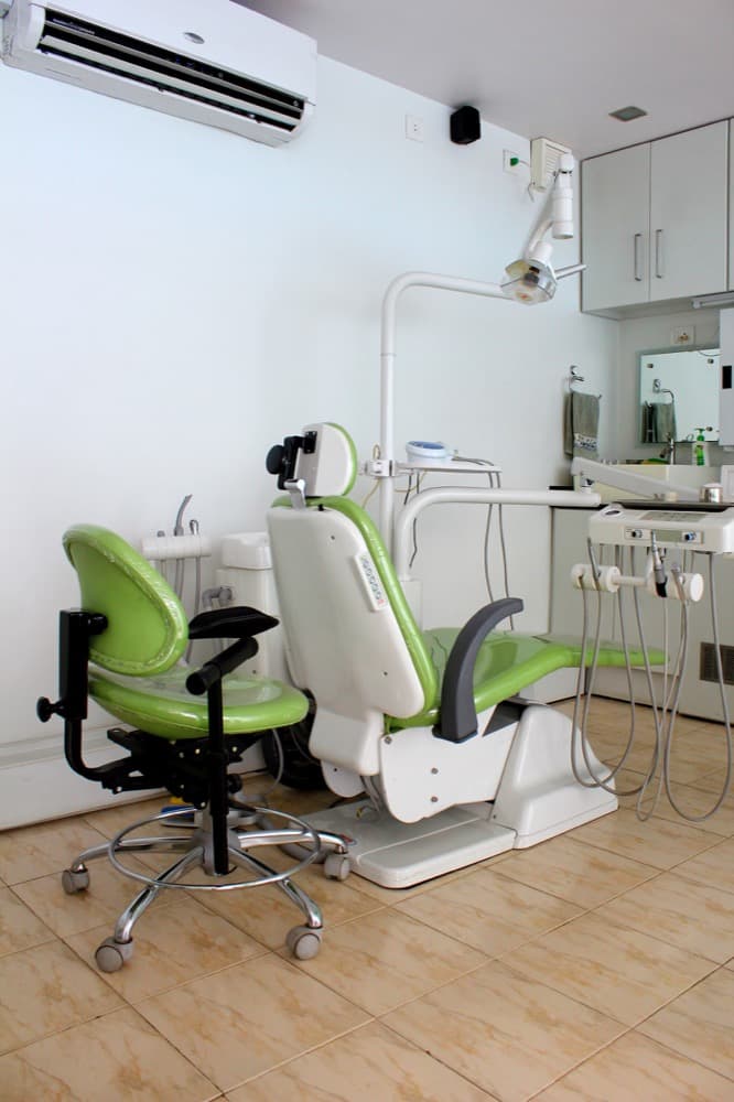 Dental treatment room with a green dental chair at Aditi Dental Care